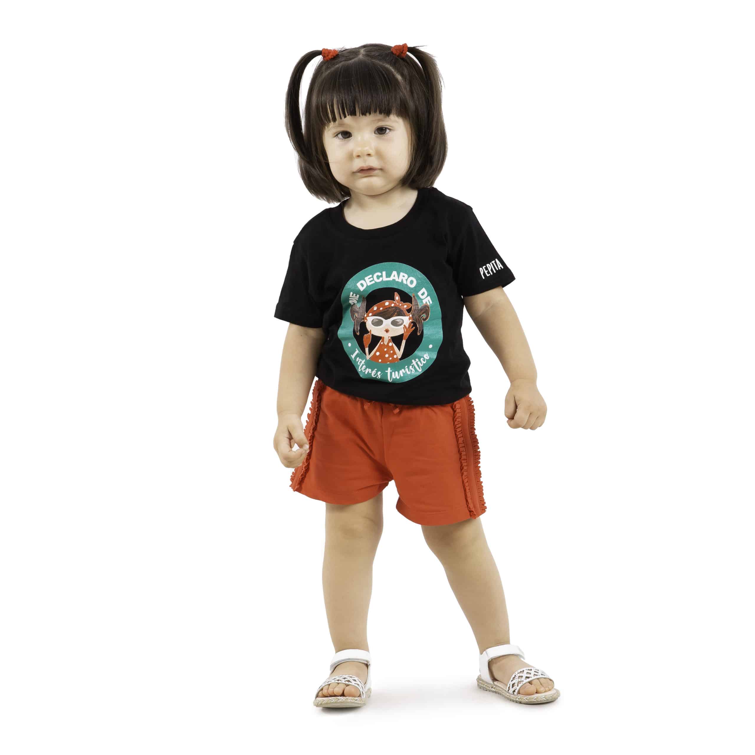 Camiseta de algodón orgánico de la marca Pepita Viajera en color negro para aquellas que se declaran de Interés Turístico. Vista puesta en modelo bebe chica